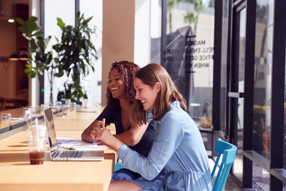 two women working on website in a workspace