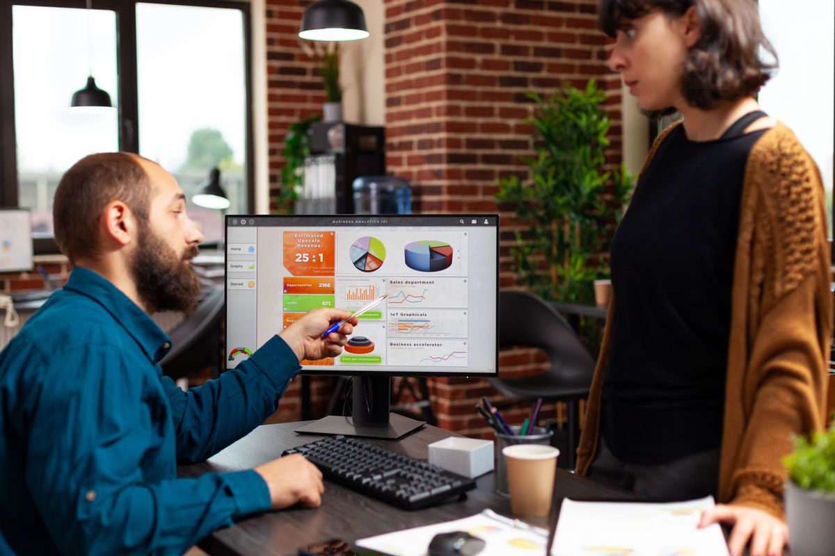 two coworkers are looking at results on. computer